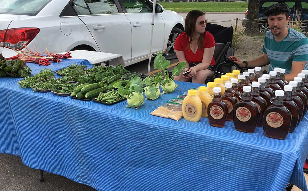 Table with vegetables and bottles of maple syrup